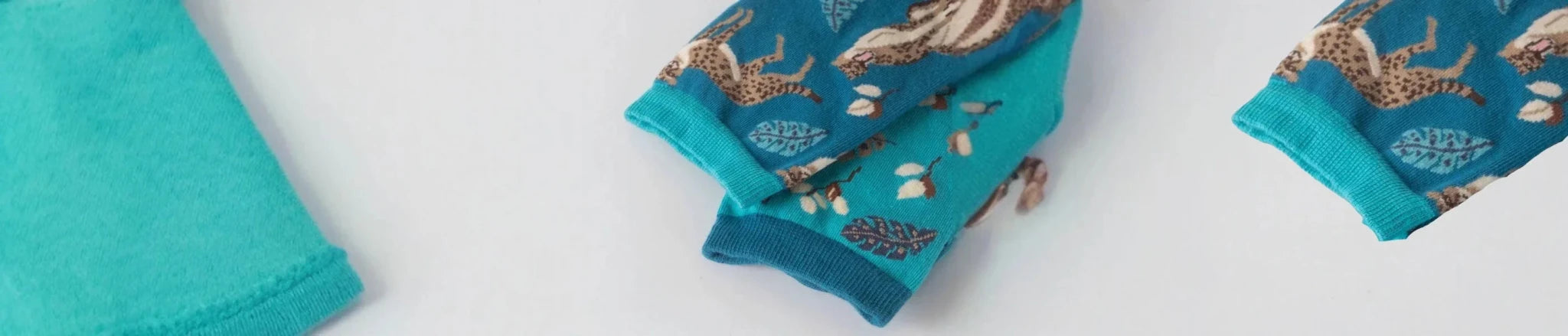 Aqua coloured patterned mismatched socks against a grey background