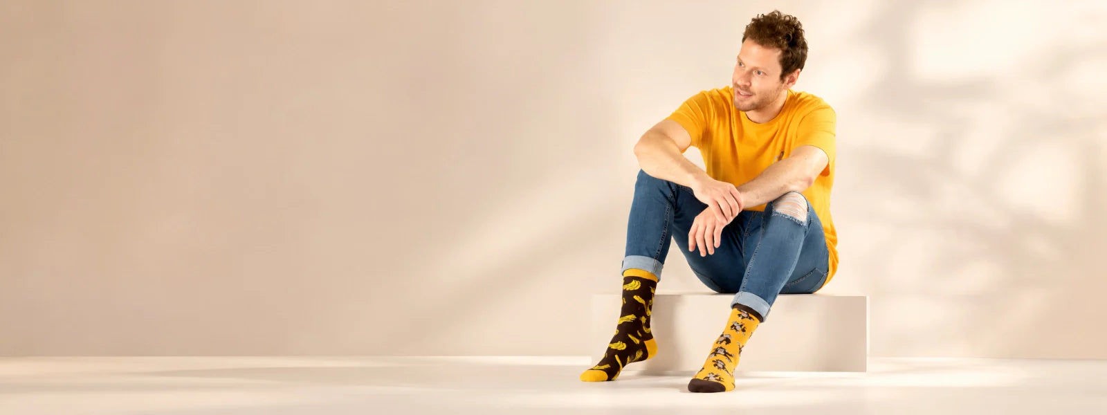 Man wearing colourful mismatched patterned socks in a minimalist lifestyle setting | Uniq Socks Australia