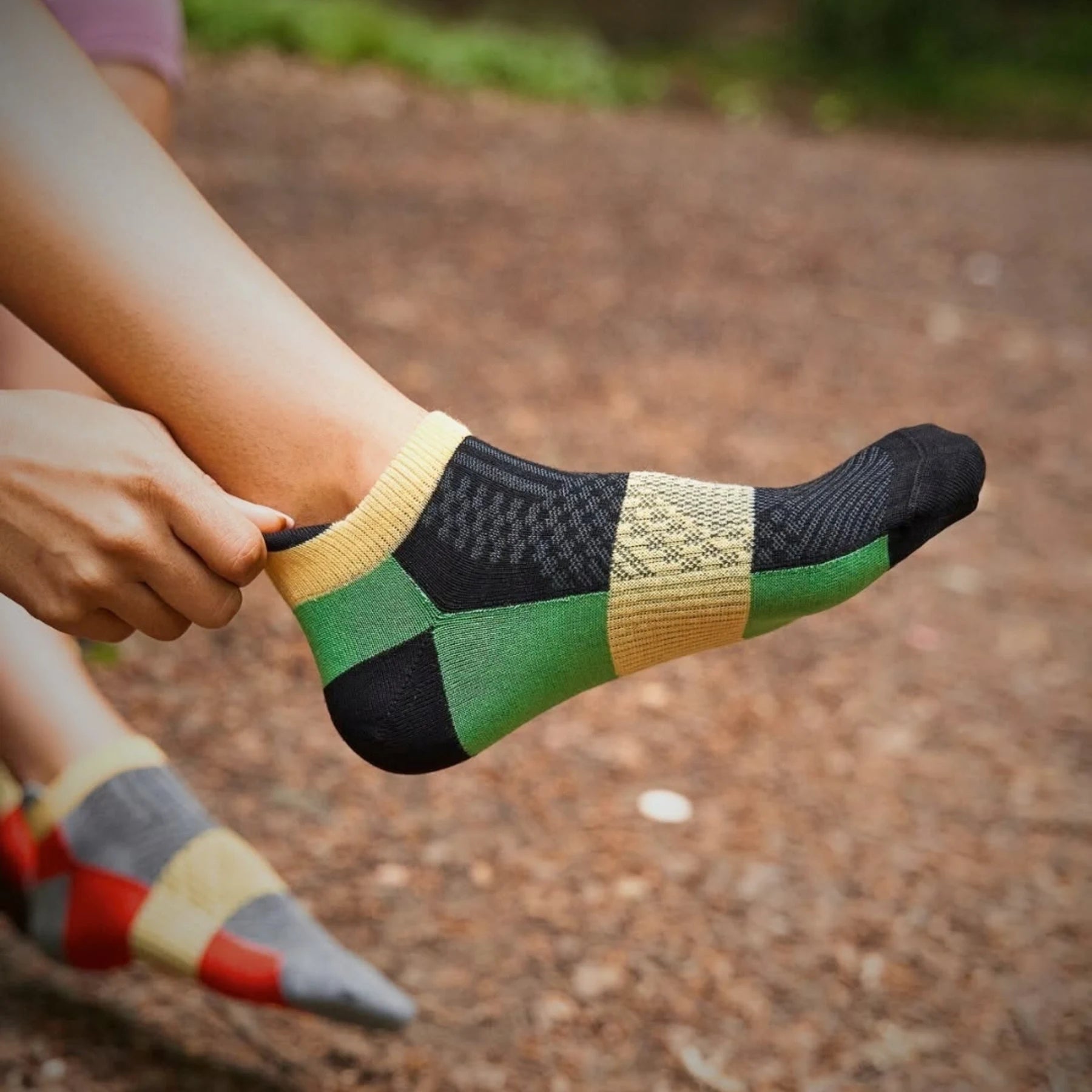 Person wearing bamboo green athletic sneaker sock with heel tab