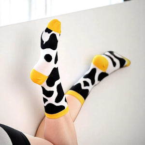 Woman wearing yellow cow themed socks