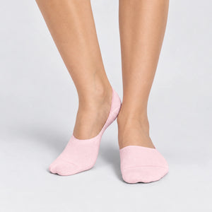 Person wearing seamless pink bamboo no-show socks on a white background