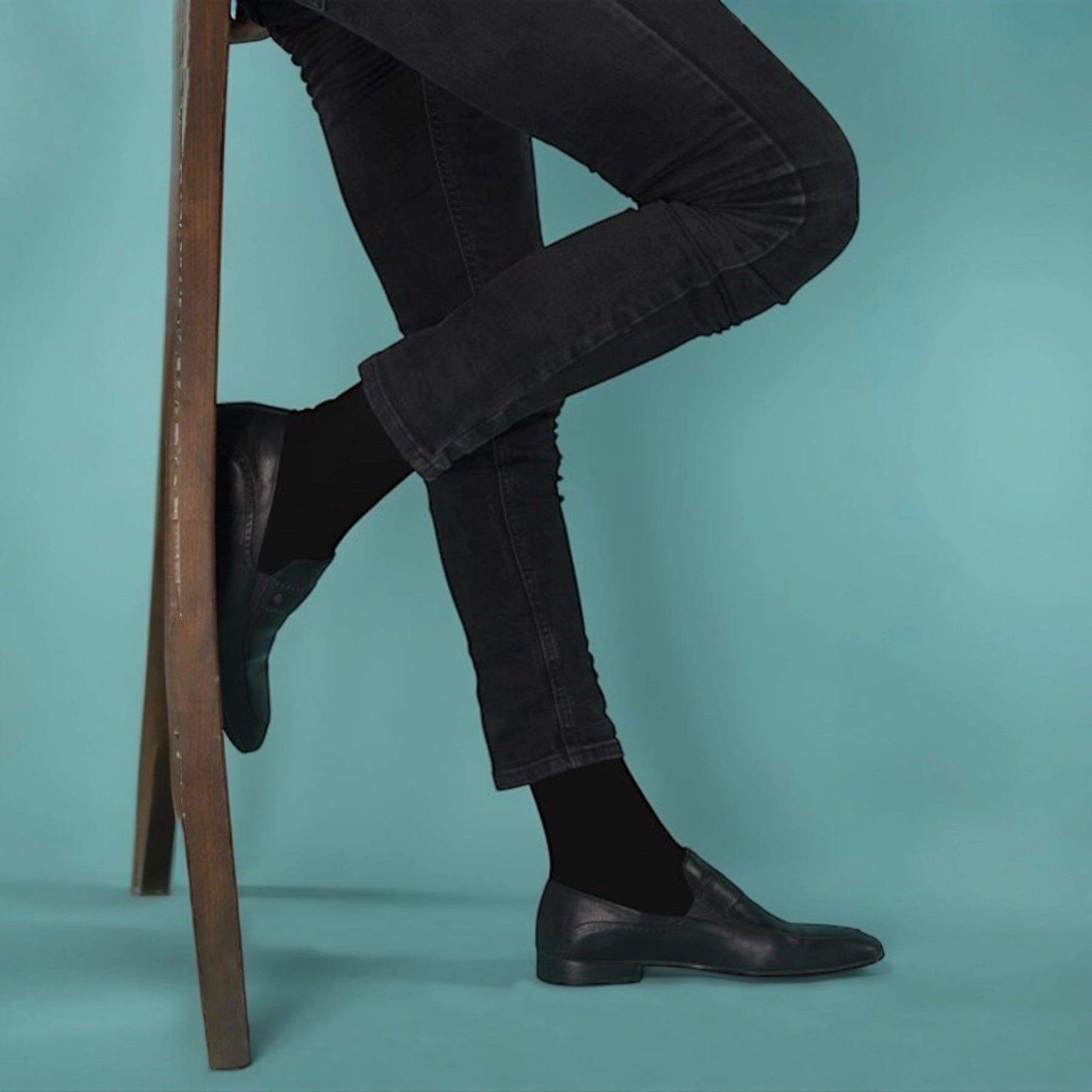 photo of man legs in slim pants wearing dark socks and leather shoes