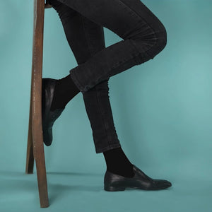 photo of man legs in slim pants wearing dark socks and leather shoes