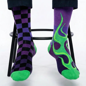 Mismatched purple and green checkered and flame-patterned socks on a white background