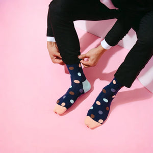 Man wearing navy socks with multiple coloured dots, toe and heel