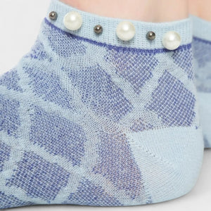 A woman wearing blue checked ankle socks finished with pearls around the cuff