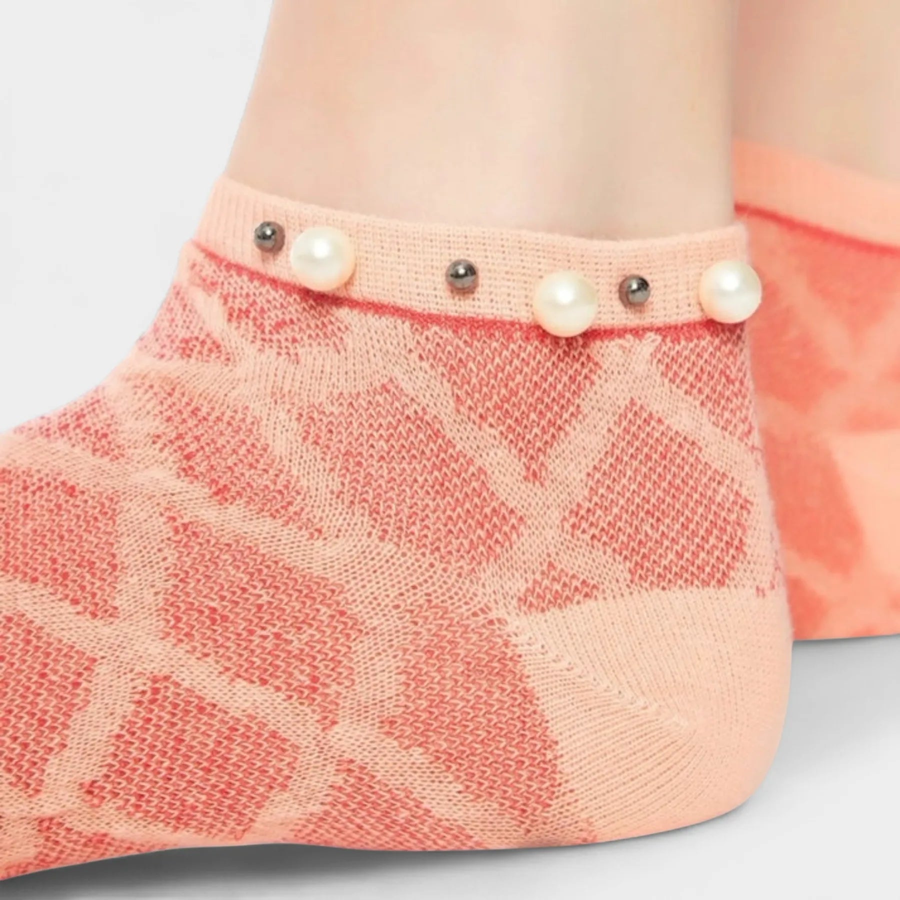 A woman wearing orange checked ankle socks finished with pearls around the cuff