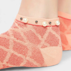 A woman wearing orange checked ankle socks finished with pearls around the cuff