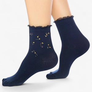 Person wearing blue quarter length socks with crystal details and a frilled cuff