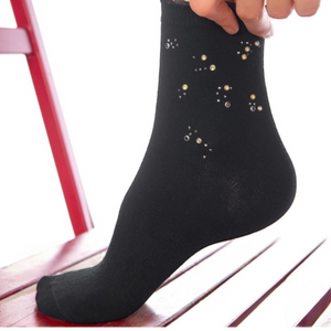 Person wearing black quarter length socks with crystal details and a frilled cuff