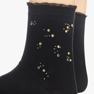 Person wearing black quarter length socks with crystal details and a frilled cuff