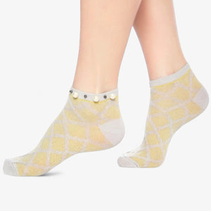 A woman wearing grey checked ankle socks finished with pearls around the cuff