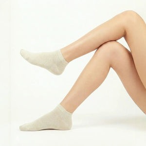 Soft beige bamboo ankle socks modeled on feet showing smooth texture and ribbed cuff