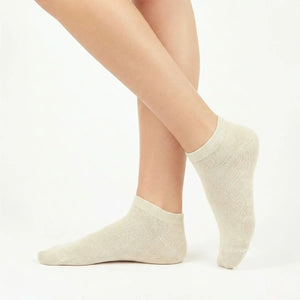 Soft beige bamboo ankle socks modeled on feet showing smooth texture and ribbed cuff