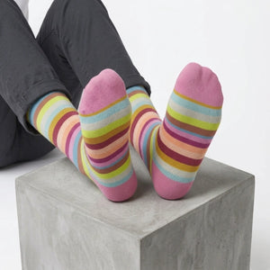 Person wearing colorful striped socks on a light background