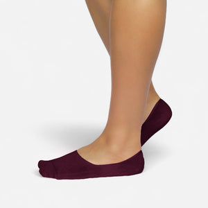 Person wearing burgundy bamboo no-show socks on a white background