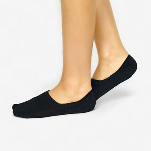 Person wearing charcoal no-show socks on a white background