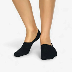 Person wearing charcoal no-show socks on a white background