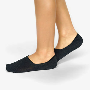 Grey no-show socks worn by a person on a light grey background