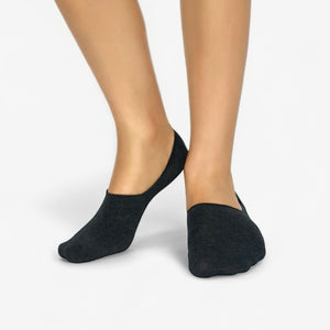 Grey no-show socks worn by a person on a light grey background