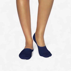 Person wearing navy bamboo no-show socks on a white background
