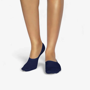 Person wearing navy bamboo no-show socks on a white background