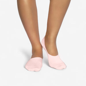 Person wearing seamless pink bamboo no-show socks on a white background