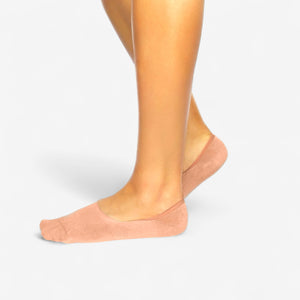 Person wearing salmon bamboo no-show socks on a light grey background