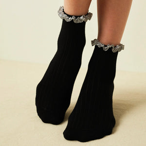 Woman wearing black ribbed quarter length socks with gingham ruffle