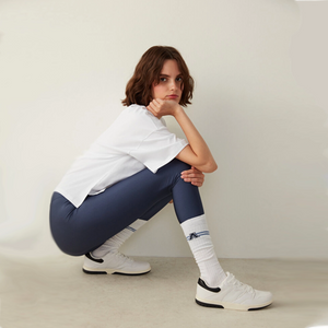 person in baseball outfit wearing white knee-high college style A-league socks