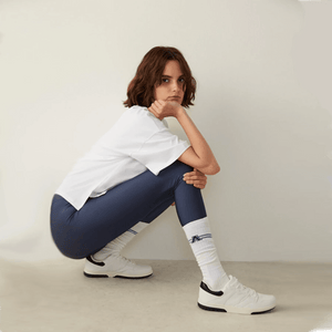 person in baseball outfit wearing white knee-high college style A-league socks