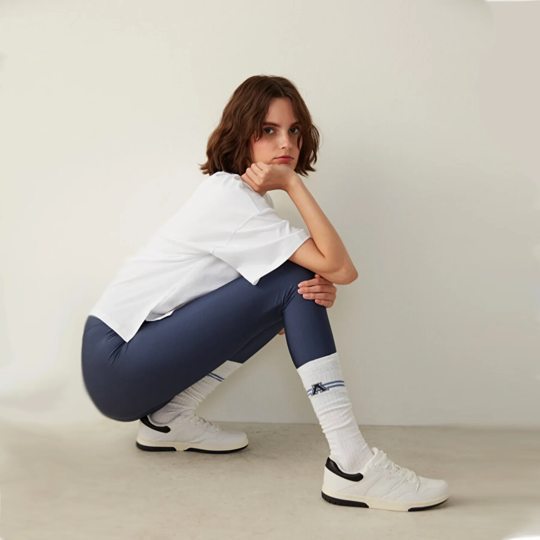 person in baseball outfit wearing white knee-high college style A-league socks