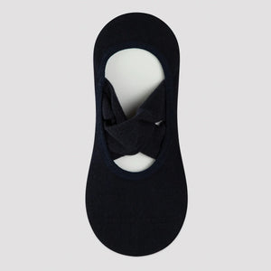 black yoga socks with crisscross straps on a neutral background