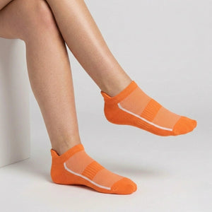 Orange ankle socks with mesh design worn by a person on a light gray background