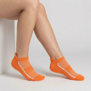 Orange ankle socks with mesh design worn by a person on a light gray background