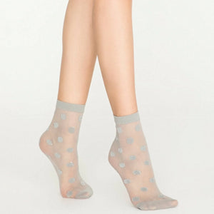 Person wearing sheer grey ankle socks with silver dots