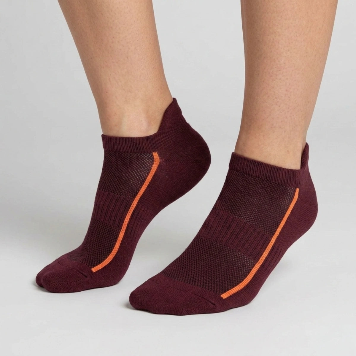 Burgundy ankle socks with mesh design worn by a person on a light gray background