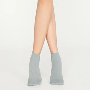 Woman wearing light grey, sparkly ankle sock