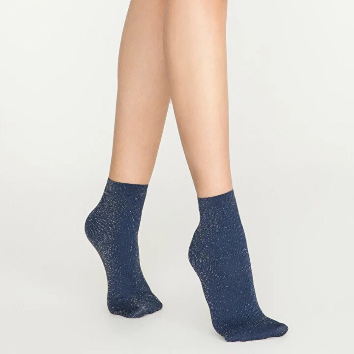Woman wearing navy and gold, sparkly ankle sock