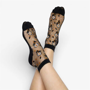 Sheer socks with white daisy pattern worn by a person on a white background