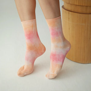 Person wearing washed orange and pink crew socks