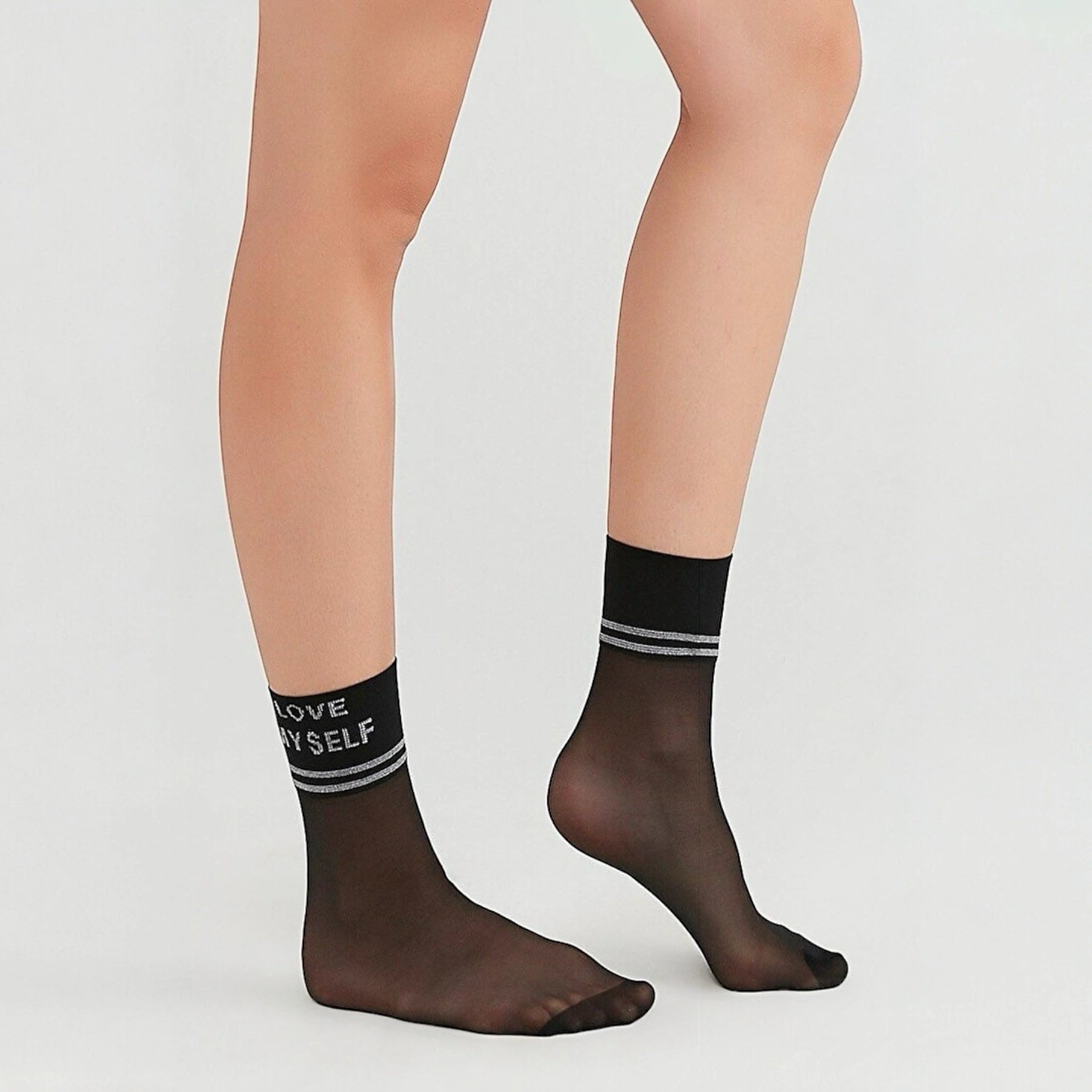 person wearing sheer black crew socks with striped cuff stating 'Love Myself'