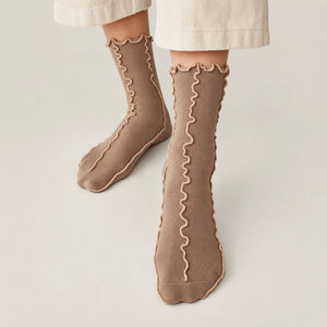 Person wearing coffee coloured, frilled socks