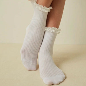 Woman wearing quarter length white, lace frilled socks