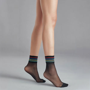 person wearing sheer black crew socks with multicoloured striped cuff