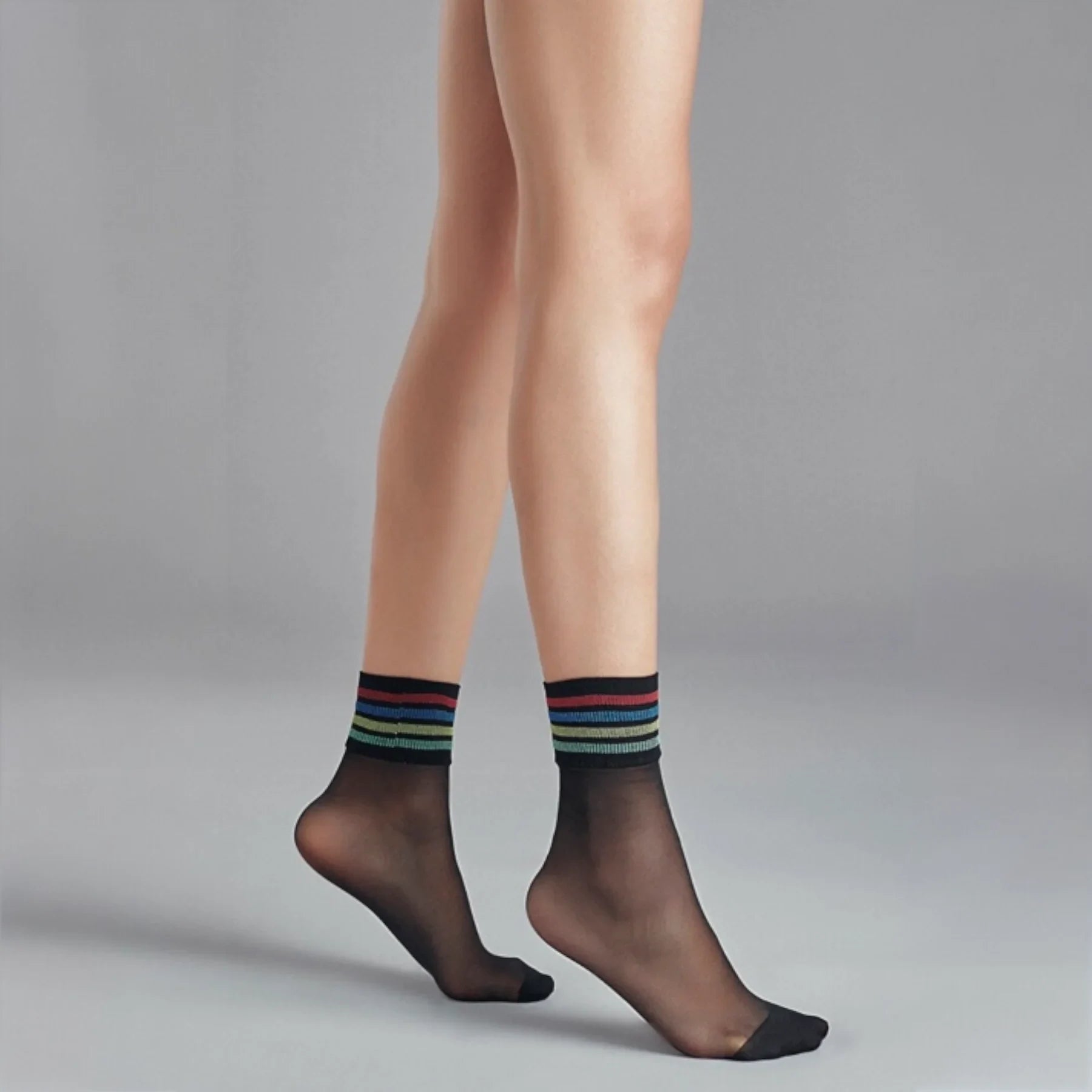 person wearing sheer black crew socks with multicoloured striped cuff