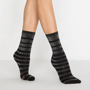 person wearing black and silver striped crew socks on a white background