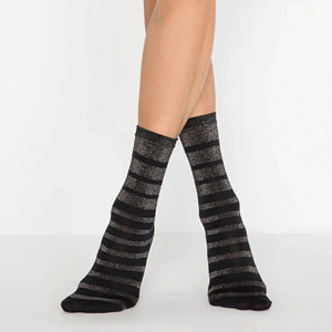 person wearing black and silver striped crew socks on a white background