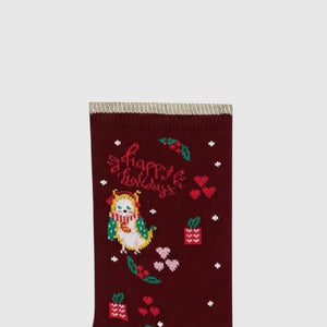 Close-up detail of brown Christmas themed sox with 'Happy Holidays' text on a light grey background