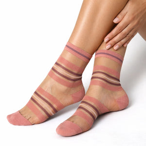 Sheer coral striped socks worn by a person on a white background